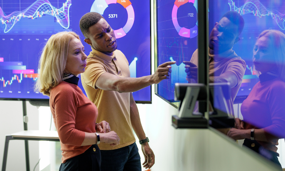 A student and prof analyze data on a colourful screen