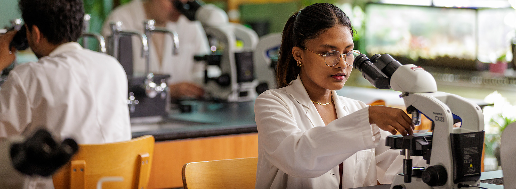 A student in a lab prepares a microscope.